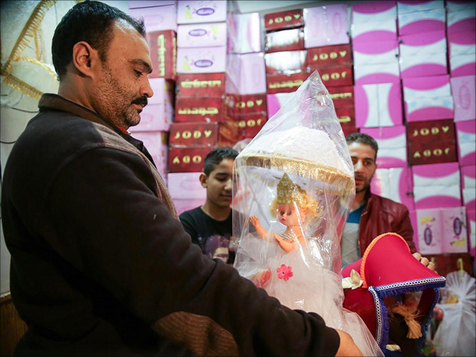 بائع يعرض عروس مولد في سوق درب البرابرة في القاهرة (الأناضول)