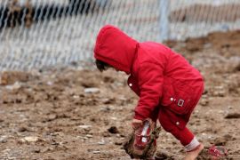 ARBIL, IRAQ - JANUARY 04: An Iraqi kid, fled from Islamic State of Iraq and Levant (ISIL) members' attacks with her family, has difficulty in walking with a pair of summer shoes at the muddy area of Harshem refugee camp in Ankawa neighborhood of Arbil, Iraq on January 04, 2015.