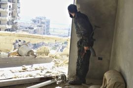 A rebel fighter stands with his weapon inside a damaged building in the northwestern Homs district of Al Waer January 18, 2015. REUTERS/Stringer (SYRIA - Tags: CIVIL UNREST CONFLICT SOCIETY)