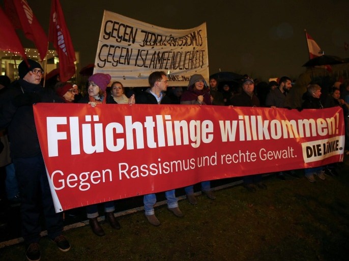 Members of the leftist Die Linke party hold a banner reading 'Refugees welcome!' during a protest against the march of BAERGIDA, Berlin's section of anti-immigration movement Patriotic Europeans Against the Islamisation of the West (PEGIDA) outside the Chancellery in Berlin January 12, 2015. REUTERS/Hannibal Hanschke (GERMANY - Tags: POLITICS CIVIL UNREST)