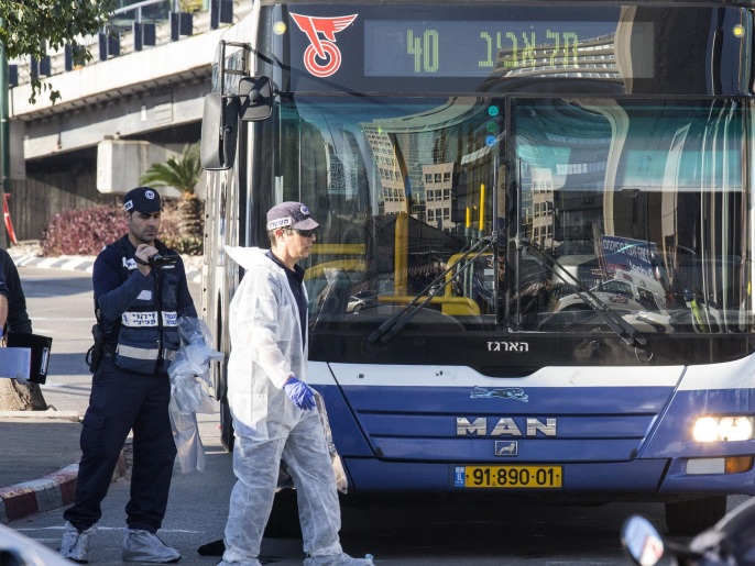 ‪محققون إسرائيليون يفحصون موقع حادث الطعن حول حافلة الركاب‬ (الفرنسية/غيتي)