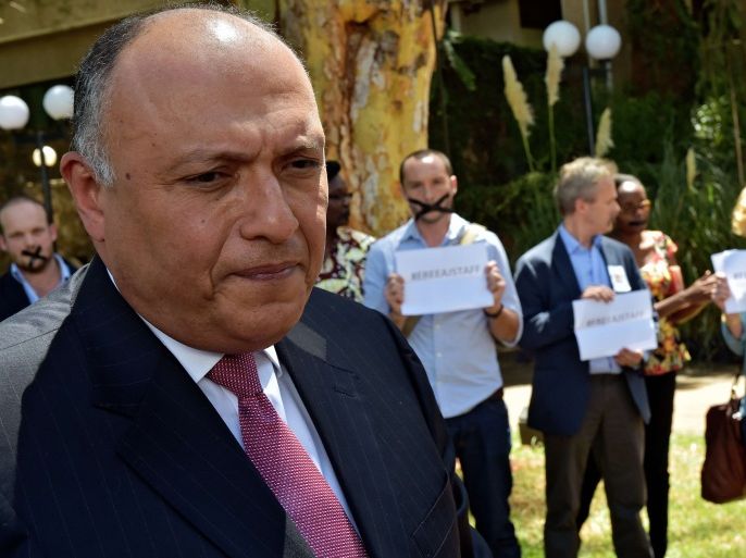 210 - Nairobi, -, KENYA : Egyptian Foreign Minister Sameh Shoukry (L) is confronted by protestors demonstrating against the incarceration of Australian journalist Peter Greste and Al-Jazeera colleagues, Mohamed Fahmy and Baher Mohamed, at a United Nations Environment programme (UNEP) reception at the United Nations headquarters in Nairobi on January 13, 2015.