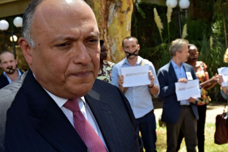 210 - Nairobi, -, KENYA : Egyptian Foreign Minister Sameh Shoukry (L) is confronted by protestors demonstrating against the incarceration of Australian journalist Peter Greste and Al-Jazeera colleagues, Mohamed Fahmy and Baher Mohamed, at a United Nations Environment programme (UNEP) reception at the United Nations headquarters in Nairobi on January 13, 2015.