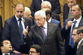 Palestinian president Mahmud Abbas stands amidst officials and security guards at the Arab foreign ministers urgent meeting at the Arab League headquarters in the Egyptian capital Cairo on January 15, 2015 to discuss the Palestinian-Israeli conflict and the situation in Libya. AFP PHOTO / MOHAMED EL-SHAHED