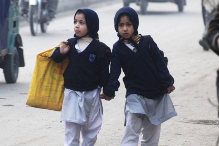 Girls carry their school bags as they walk along a road while heading to their school after it reopened in Peshawar January 12, 2015. Children streamed back to school across Pakistan on Monday in an anxious start to a new term following last month's massacre of 134 students at an army-run school in the volatile northwestern city of Peshawar. Most schools across the country of 180 million had been shut until Monday for an extended winter break in the aftermath of the Dec. 16 attack when Taliban militants broke into Army Public School and methodically killed the children. REUTERS/Khuram Parvez (PAKISTAN - Tags: EDUCATION CIVIL UNREST TPX IMAGES OF THE DAY)