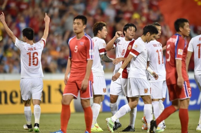 China (in white) celebrate scoring their second goal against North Korea during their Group B football match of the AFC Asian Cup in Canberra on January 18, 2015. AFP PHOTO/Peter PARKS --IMAGE RESTRICTED TO EDITORIAL USE - STRICTLY NO COMMERCIAL USE