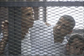 (FILES) - A file picture taken on June 23, 2014 at the police institute near Cairo's Tora prison, shows Al-Jazeera news channel's Australian journalist Peter Greste (L) and his colleagues, Egyptian-Canadian Mohamed Fadel Fahmy (C) and Egyptian Baher Mohamed, listening to the verdict inside the defendants cage during their trial for allegedly supporting the Muslim Brotherhood. Egypt's top court ordered on January 1, 2015 a retrial of three Al-Jazeera reporters whose imprisonment on charges of aiding the Muslim Brotherhood triggered global outrage, but kept them in custody pending a new hearing. AFP PHOTO / KHALED DESOUKI