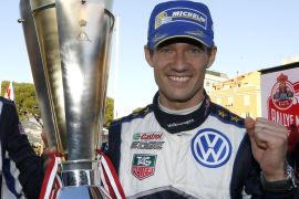 French driver Sebastien Ogier holds the trophy during the podium ceremony, after his victory in the 83rd Monte-Carlo Rallye on January 25, 2015, in Monaco. AFP PHOTO / VALERY HACHE