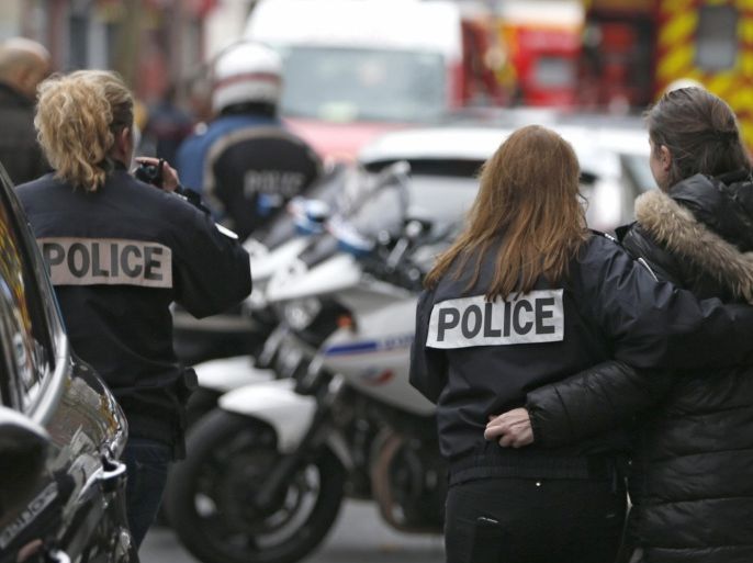 French police assist a woman after a shooting in the street of Montrouge near Paris January 8, 2015. A police officer was wounded in a shootout in southern Paris on Thursday, a police source told Reuters, adding that it was unclear at this stage whether there was any link to the killings at the Charlie Hebdo magazine.Television station iTELE said two police officers were lying on the ground after the attack. REUTERS/Charles Platiau (FRANCE - Tags: CRIME LAW)