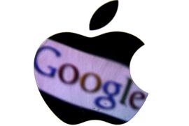 A Google trademark is reflected in Apple logo in this photo illustration taken in Berlin, August 31, 2012. REUTERS/Pawel Kopczynski