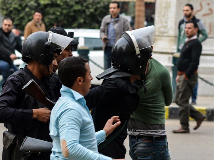 Egyptian policemen detain a supporter of the People's Alliance Party during a demonstration in Cairo's Talaat Harb square, near Tahrir square, on January 24, 2015.