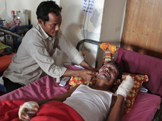 A relative tries to comfort Amulla, 35, a victim of a recent bomb attack, as he receives treatment at a medical college hospital during the ongoing nationwide blockade called by the opposition Bangladesh Nationalist Party (BNP), in Dhaka, Bangladesh, Friday, Jan. 23, 2015. He is one of the victims of more than two weeks of attacks sparked by the latest clash between Bangladesh's two main, long-feuding political factions since Jan. 5, the one-year anniversary of the last election. Supporters of former Prime Minister Khaleda Zia, who boycotted the last vote, demand that the government resign and hold new elections immediately, but Prime Minister Sheikh Hasina says her government will remain in office until her term ends in 2019. (AP Photo/A.M. Ahad)