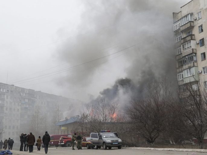 Smoke and flames rise above a burning building after shelling in the eastern Ukrainian city of Mariupol, 24 January 2015. Fifteen civilian people were killed and 46 injured during a shelling at Jan.24 morning in Mariupol according to a UNIAN agency report.