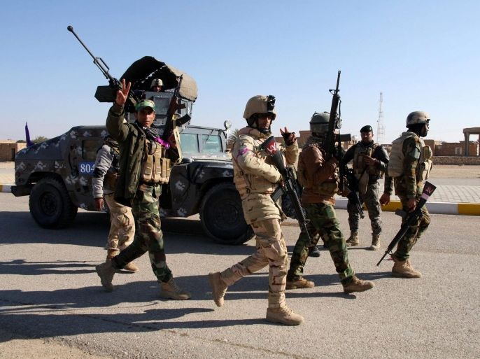 A picture made available on 23 December 2014 shows Iraqi soldiers patrolling an area at al-Furat town, west Iraq, 22 December 2014. According to media reports, al-Furat town in Anbar province was recaptured by government forces along with Shiites militia supported by airstrikes from an international anti-IS coalition, after the Islamic State's initial lightning offensive against Iraqi security forces in June 2014.