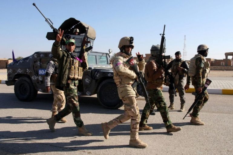 A picture made available on 23 December 2014 shows Iraqi soldiers patrolling an area at al-Furat town, west Iraq, 22 December 2014. According to media reports, al-Furat town in Anbar province was recaptured by government forces along with Shiites militia supported by airstrikes from an international anti-IS coalition, after the Islamic State's initial lightning offensive against Iraqi security forces in June 2014.