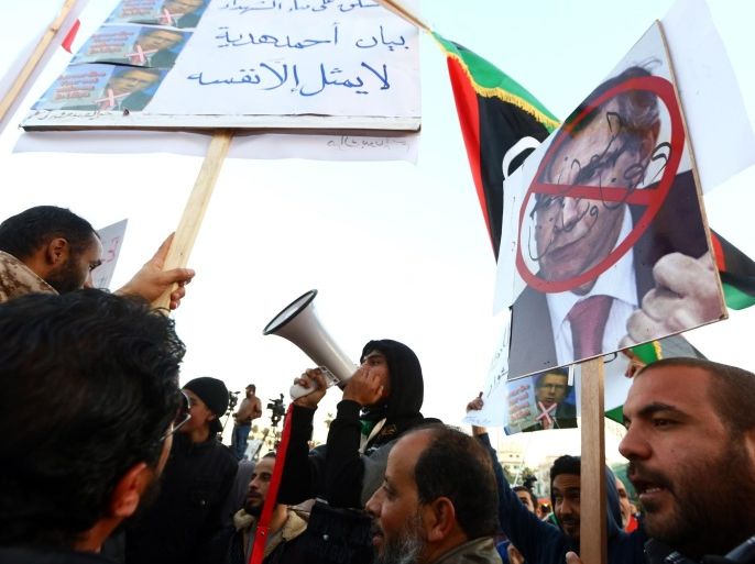 A Libyan man holds a placard showing UN special envoy for Libya, Bernardino Leon (R) during a rally of supporters of 'Fajr Libya' (Libya Dawn), a mainly-Islamist alliance, against the dialogue on January 16 ,2015 in Tripoli's central Martyr's Square, as peace talks between the country's warring factions kicked off in Geneva. The North African nation has been gripped by deepening conflict since the overthrow of dictator Moamar Kadhafi in a NATO-backed uprising in 2011, with rival governments and powerful militias battling for control of key cities and the nation's oil wealth. AFP PHOTO / MAHMUD TURKIA