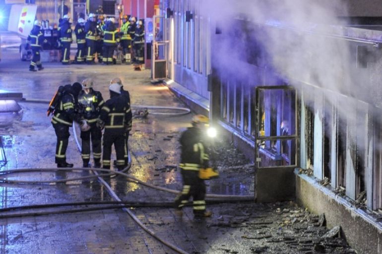 Firemen work outside a still smoking cellar mosque in Eskilstuna, Sweden, Thursday, Dec. 25, 2014. Five of the twenty at prayer inside were taken to hospital after inhaling smoke when a burning object was hurled through a window, setting fire to the building in the early afternoon. (AP Photo/Pontus Stenberg) SWEDEN OUT
