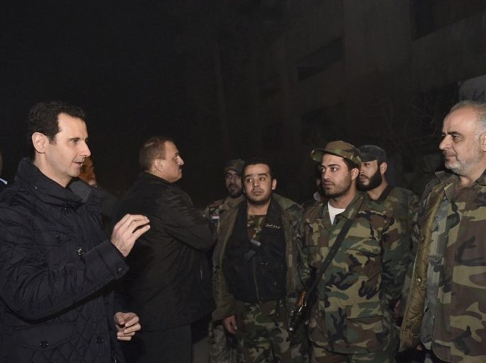 Syrian President Bashar al-Assad (L) talks to soldiers during a visit to Jobar, northeast of Damascus, in this handout photograph distributed by Syria's national news agency SANA on January 1, 2015. Al-Assad visited a district on the outskirts of Damascus and thanked soldiers fighting "in the face of terrorism", his office said on its Twitter account on Wednesday, posting pictures of the rare trip. The account said the visit took place in Jobar, northeast of Damascus, on the occasion of the New Year. The district came under heavy Syrian air force strikes on Wednesday according to the Britain-based Syrian Observatory for Human Rights, which monitors the nearly four-year conflict. REUTERS/SANA/Handout (SYRIA - Tags: CIVIL UNREST POLITICS RELIGION CONFLICT) ATTENTION EDITORS - THIS PICTURE WAS PROVIDED BY A THIRD PARTY. REUTERS IS UNABLE TO INDEPENDENTLY VERIFY THE AUTHENTICITY, CONTENT, LOCATION OR DATE OF THIS IMAGE. FOR EDITORIAL USE ONLY. NOT FOR SALE FOR MARKETING OR ADVERTISING CAMPAIGNS