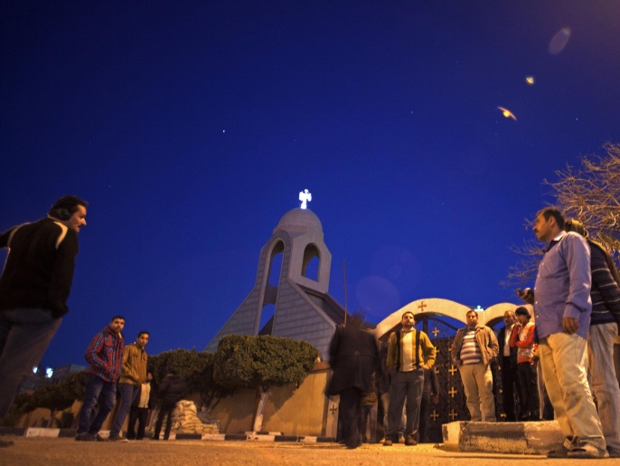 مواطنون يتجمعون قرب كنيسة مريم العذراء عقب هجوم استهدف شرطيا يحرس الكنيسة (أسوشيتد برس)