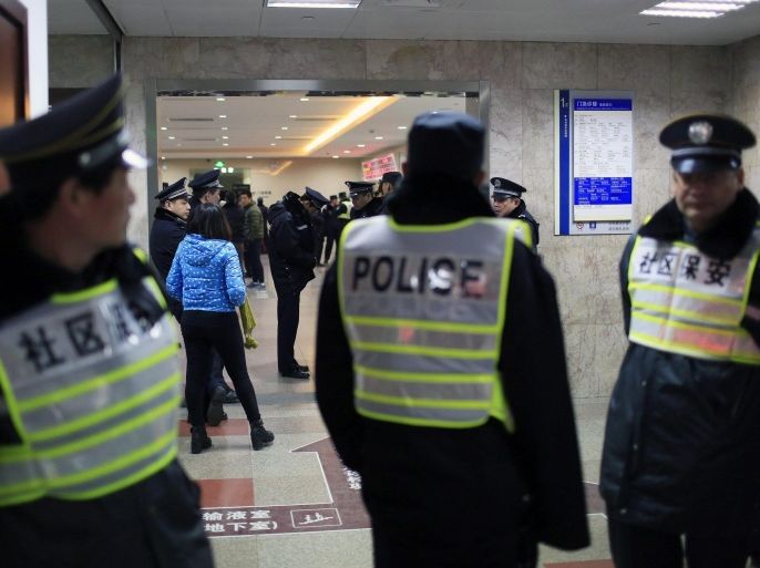 Security personnel (front) and policemen stand next to an entrance to a hospital where injured people of a stampede incident are treated, in Shanghai, January 1, 2015. At least 35 people were killed and 42 were injured in a stampede during a New Year's celebration on the Bund, a waterfront area in central Shanghai, official Chinese government television CCTV America reported on its website. REUTERS/Aly Song (CHINA - Tags: DISASTER HEALTH SOCIETY)