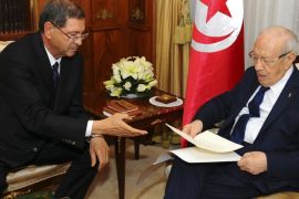 New Tunisian Prime Minister Habib Essid, left, gives Tunisian President Beji Caid Essebsi the list of the cabinet members, Friday, Jan.23, 2015 in Tunis. A month after the last election ending its democratic transition, Tunisia announces the makeup of the new coalition government tasked with seeing the country out of its current economic crisis. (AP Photo/Hassene Dridi)