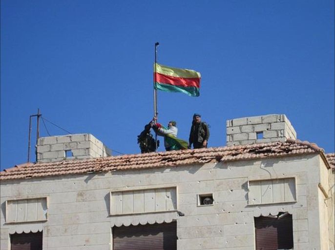مسلحون أكراد يرفعون علم حزب العمال الكردستاني على مخفر تابع للنظام السوري شمال مدينة الحسكة بعد السيطرة عليه