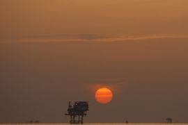 (FILE) A file photo dated 15 July 2010 showing the sun setting over an oil well in the Gulf of Mexico, USA. Reports on 12 January 2015 state the oil price has fallen three per cent to its lowest level since April in 2009. Goldman Sachs has also lowered its three-month forecast of Brent crude oil, from the earlier forecast 80 USD to 42 USD and said it expects the price to stay close to 40 USD for the first six months of 2015.