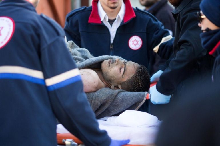 Israeli medics transport a Palestinian man on a gurney who stabbed and wounded at least five passengers in an attack on a Tel Aviv bus on January 21, 2015. The attacker struck in the morning rush hour in the heart of Israel's commercial capital before being shot by a passing prison officer, Israeli police said. AFP PHOTO / OREN ZIV