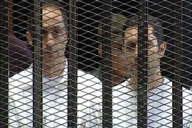 epa04576210 (FILE) A file photograph dated 03 August 2011, shows Gamal (L) and Alaa (R), sons of former Egyptian President Hosni Mubarak standing behind the bars during their trial and that of their father and aides at the police academy in Cairo, Egypt. An Egyptian court on 22 January 2015 ordered the release of the two sons of deposed president Hosni Mubarak pending their retrial in a fraud case, days before the anniversary of the start of the 2011 uprising that forced their father to step down. Egypt's top appeal court this month overturned the conviction of Mubarak and his sons Alaa and Gamal and ordered a retrial for the three on charges of spending more than 100 million Egyptian pounds (14 million dollars) of public money on their private residences. EPA