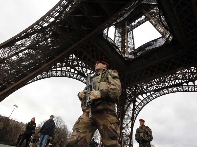 A French soldier patrols near the Eiffel Tower as part of the highest level of "Vigipirate" security plan after a shooting at the Paris offices of Charlie Hebdo January 10, 2015. French police searched for a female accomplice to militant Islamists behind deadly attacks on the satirical Charlie Hebdo weekly newspaper and a kosher supermarket and maintained a top-level anti-terrorist alert ahead of a Paris gathering with European leaders and demonstration set for Sunday. In the worst assault on France's homeland security for decades, 17 victims lost their lives in three days of violence that began with an attack on the Charlie Hebdo weekly on Wednesday and ended with Friday's dual hostage-taking at a print works outside Paris and kosher supermarket in the city. REUTERS/Eric Gaillard (FRANCE - Tags: CRIME LAW MILITARY)