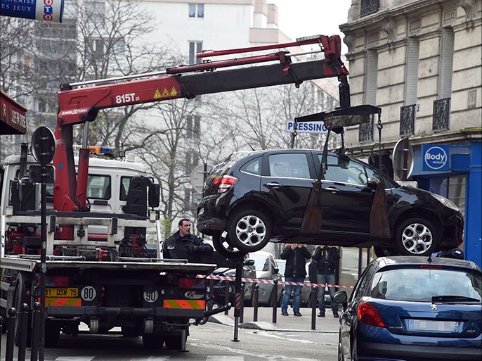 A truck tows the car used by armed gunmen who stormed the Paris offices of satirical newspaper Charlie Hebdo, killing 12 people, on January 7, 2015 in Paris. A source close to the investigation said two men "armed with a Kalashnikov and a rocket-launcher" stormed the building in central Paris and "fire was exchanged with security forces". The source said a gunman had hijacked a car and knocked over a pedestrian while attempting to speed away