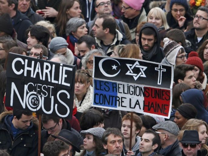 Citizens carrying placards reading "Charlie it is us" and "The religions united against the hatred" take part in a Hundreds of thousands of French citizens solidarity march (Marche Republicaine) in the streets of Paris January 11, 2015. French citizens will be joined by dozens of foreign leaders, among them Arab and Muslim representatives, in a march on Sunday in an unprecedented tribute to this week's victims following the shootings by gunmen at the offices of the satirical weekly newspaper Charlie Hebdo, the killing of a police woman in Montrouge, and the hostage taking at a kosher supermarket at the Porte de Vincennes. REUTERS/Charles Platiau (FRANCE - Tags: CRIME LAW POLITICS CIVIL UNREST SOCIETY)