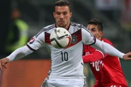 NUREMBERG, GERMANY - NOVEMBER 14: Lukas Podolski (L) of Germany battles for the ball with Jean Carlos Garcia of Gibraltar during the EURO 2016 Group D Qualifier match between Germany and Gibraltar at Grundig Stadion on November 14, 2014 in Nuremberg, Germany.