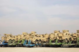 U.S. Army MRAP vehicles stand loaded onto local trucks before being shipped to Kuwait during work to shrink Bagram Air Field in the Parwan province of Afghanistan January 2, 2015. The base is being shrunk by demolishing large swaths of housing in order to hold roughly 13,000 foreign troops, mostly Americans, who will remain in the country under a new two-year mission named "Resolute Support" to train Afghan troops. REUTERS/Lucas Jackson (AFGHANISTAN - Tags: CIVIL UNREST POLITICS MILITARY)