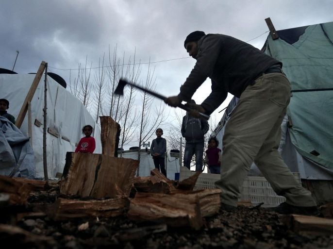 A Syrian refugee splits wood as he prepares for the possibility of a snow storm at a Syrian refugee camp, in Deir Zannoun village, Bekaa valley, Lebanon, on Monday, Jan. 5, 2015. A snow storm is expected to hit Lebanon Monday affecting Syrian refugees, many of whom live in tents without heating. The government estimates there are about 1.5 million Syrians in Lebanon, about one-quarter of the total population. (AP Photo/Hussein Malla)
