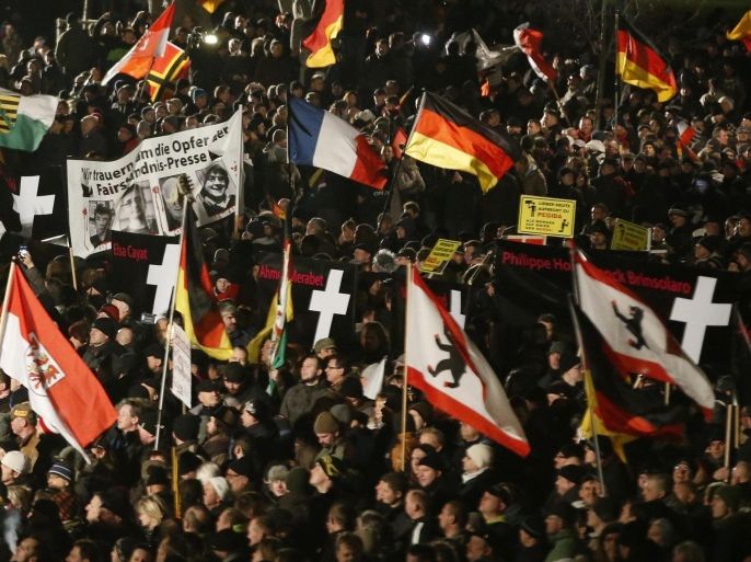 Supporters of anti-immigration movement Patriotic Europeans Against the Islamisation of the West (PEGIDA) hold flags during a demonstration in Dresden January 12, 2015. A record 25,000 anti-Islamist protesters marched through the east German city of Dresden on Monday, many holding banners with anti-immigrant slogans, and held a minute's silence for the victims of last week's attacks in France. REUTERS/Fabrizio Bensch (GERMANY - Tags: POLITICS CIVIL UNREST MEDIA CRIME LAW)