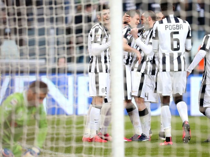 Juventus' Swiss defender Stephan Lichtsteiner celebrates after scoring with his teammates during the Italian Serie A football match Juventus Vs Chievo Verona on January 25, 2015 at the Juventus Stadium in Turin. AFP PHOTO / MARCO BERTORELLO