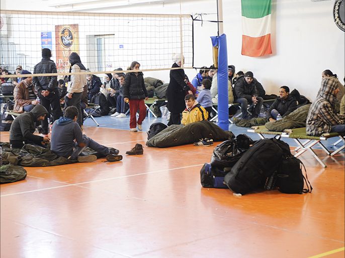 Migrants are seen at a first aid center set up at the Gallipoli fitness center, on December 31, 2014, after arriving in Italy aboard the Moldovan-flagged ship Blue SKy M. in the port of Gallipoli, in southeastern of Italy. Some 700 illegal migrants rescued from the ship near the Greek island of Corfu arrived in Italy on December 31 after their boat was intercepted while drifting towards the coast. Police and maritime authorities will investigate how the migrants, reportedly mainly from Syria, came to be hidden on the Blue Sky M as it sailed to the Croatian port of Rijeka. AFP PHOTO / NUNZIO GIOVE