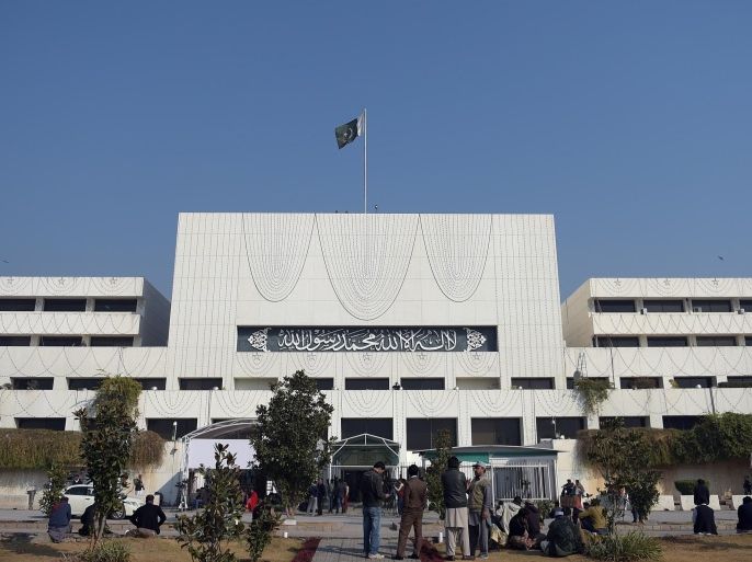 Pakistani security and media officials gather in front of the Parliament House building in Islamabad on January 6, 2015, as legislators voted for an amendment in the constitution that will protect the establishment of military courts. Pakistan's lower house of parliament on January 6 approved the setting-up of military courts to hear terrorism-related cases, after a Taliban massacre at a military-run school in the northwest shocked the nation. Prime Minister Nawaz Sharif had announced the plan after the militants gunned down 134 children and 16 adults at the Peshawar school last month. AFP PHOTO/ Aamir QURESHI