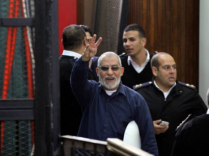 CAIRO, EGYPT - DECEMBER 24: Muslim Brotherhood's Supreme Guide Mohamed Badie (C), charged with breaking out of jail in 2011, flashes Rabia sign during his trial in Police Academy in the east of Cairo on December 24, 2014. Ousted President Mohamed Morsi and 190 other defendants, including Mohamed Badie and Mohamed El-Beltagy, are charged with breaking out of jail in 2011.