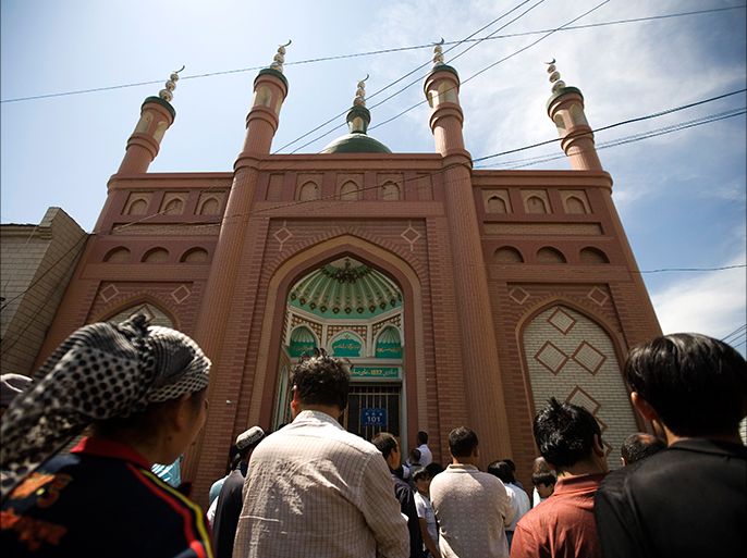 epa01788723 Ethnic Uygur Muslims walk outside a mosque in Urumqi, Xinjiang province, China, 09 July 2009. Several mosques around the city remain closed following the unrest that started on 05 July which has so far left over 140 people dead according to official estimates. Questions remain as to whether mosques will be open for Friday noon prayers, regarded by Islam as an obligatory prayer for every adult male Muslim. EPA/DIEGO AZUBEL