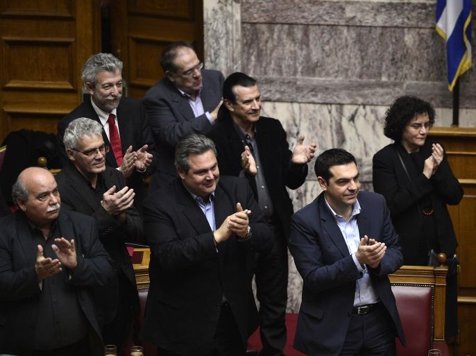 Greece's prime minister Alexis Tsipras (R) and members of his government applaud as they got the confidence vote early on February 11, 2015. Greece's new leftist government fine-tuned a 10-point plan aimed at persuading its international creditors to reluctantly rethink their bailout terms and prevent the country from going bust. AFP PHOTO/ Louisa Gouliamaki