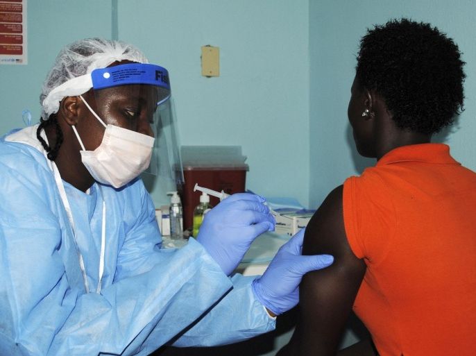 A health worker injects a woman with an Ebola vaccine during a trial in Monrovia, February 2, 2015. Liberia began a trial of experimental Ebola vaccines on Monday, involving thousands of volunteers as part of an effort to slow the spread of the deadly haemorrhagic fever and prevent future outbreaks. The epidemic has killed more than 8,800 people in West Africa since it began more than a year ago, overwhelming weak healthcare systems in Guinea, Liberia and Sierra Leone. Its spread now appears to be slowing, especially in Liberia which currently has just a handful of cases. REUTERS/James Giahyue (LIBERIA - Tags: DISASTER HEALTH)
