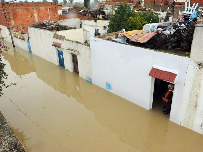 A woman looks through her door at floodwaters in the northern Tunisia village of Houcine, on November 2, 2011, near Mejez al Bab in the Beja province. Three days of heavy rain have already killed three people in the governorate of Zaghouan.