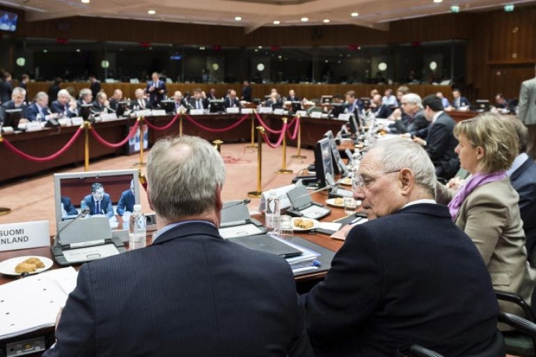 German Finance Minister Wolfgang Schaeuble, bottom right, talks with Finnish Finance Minister Antti Rinne, left, during a meeting of EU finance ministers at the EU Council building in Brussels Tuesday, Feb. 17, 2015. (AP Photo/Geert Vanden Wijngaert)