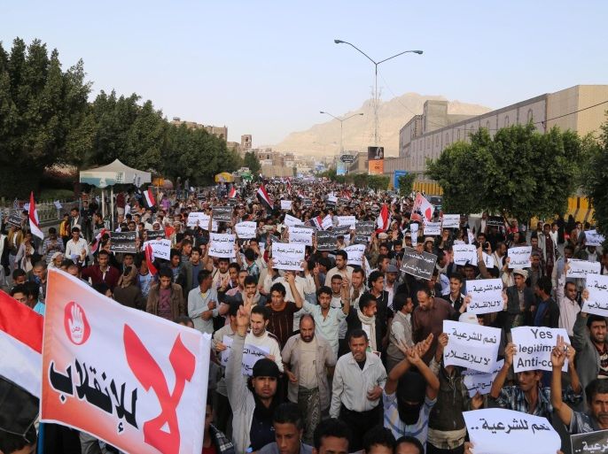 Protesters march during an anti-Houthi demonstration in Sanaa, Yemen, Wednesday, Feb. 25, 2015. Arabic writing on a banner at bottom left that reads,"no to the coup." and the other banners read "yes to legitimacy, no to the coup." A group of oil-rich Arab Gulf countries threw their support behind Yemen's embattled president Wednesday as the group's chief visited Abed Rabbo Mansour Hadi in a southern port city he fled to amid the Shiite rebel power grab in the capital, Sanaa. (AP Photo/Nadia Abdullah)