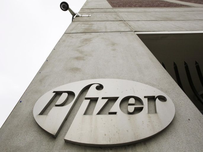 FILE - In this May 4, 2014 file photo, a security camera hangs above the Pfizer logo on the exterior of a former Pfizer factory in the Brooklyn borough of New York. The pharmaceutical giant reports quarterly financial results on Tuesday, Jan. 27, 2015. (AP Photo/Mark Lennihan, File)