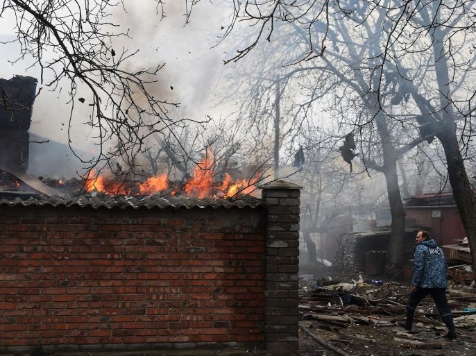 A firefighter passes a burning house after shelling destroyed several homes in the eastern Ukrainian city of Donetsk on February 3, 2015. At least 16 civilians have been killed in fierce fighting across east Ukraine over the past 24 hours, government and rebel officials said on February 3. Five civilians were killed around battleground town Debaltseve, six in and around rebel centre Donetsk, and five in neighbouring Lugansk region, pro-Kiev officials and rebels said.AFP PHOTO / DOMINIQUE FAGET