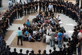 Anti-terror and riot police surround former colleagues detained on suspicion of spying or of illegally wiretapping government officials, including prime minister Recep Tayyip Erdogan and Turkey’s spy chief, inside a courhouse in Istanbul, Turkey Saturday, July 26, 2014. Turkey's state-run news agency says an Istanbul court has charged 20 police officers with illegal wiretapping and ordered their arrest pending a trial. The Anadolu Agency said 49 other officers are still waiting late Saturday to be questioned and face possible charges.(AP Photo)