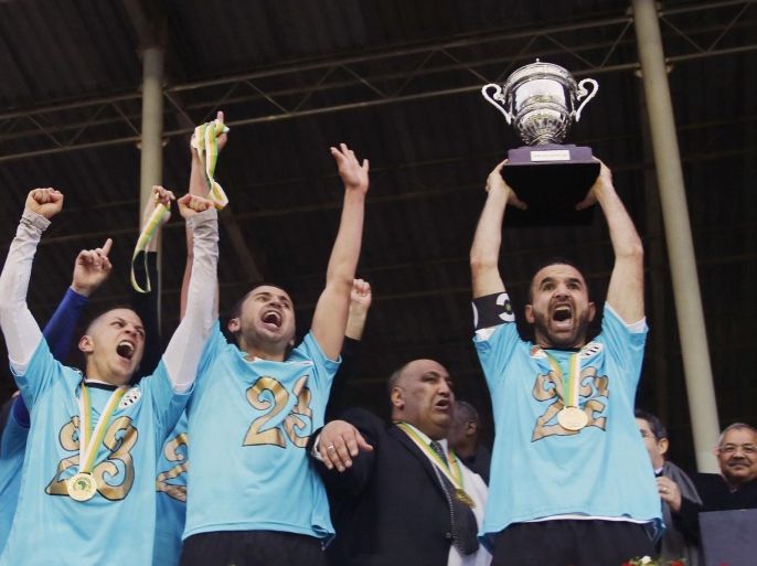 Farid Mellouli, captain of Algeria's Entente Setif, raises the trophy after winning the African Super Cup soccer match against Egypt's Al-Ahly at the Mustapha Tchaker Stadium in Blida February 21, 2015. Entente Setif became the first Algerian club to win the African Super Cup after they edged out Egyptian giants Al Ahli in a dramatic penalty shootout on Saturday. REUTERS/Amr Abdallah Dalsh (ALGERIA - Tags: SPORT SOCCER)